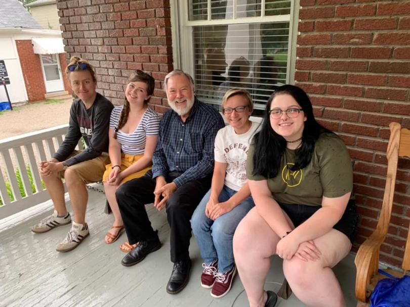 photo of five people sitting on a bench on the outside porch of the UK Appalachian Center