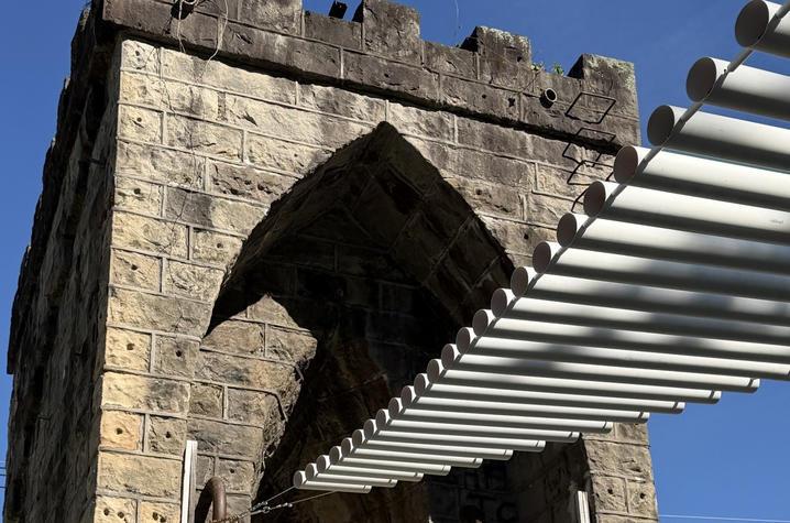 image of sandstone structure with wooden bridge canopy attached